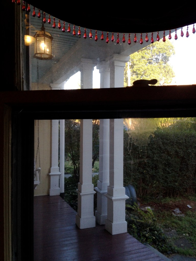 View to the porch through a dirty window.
